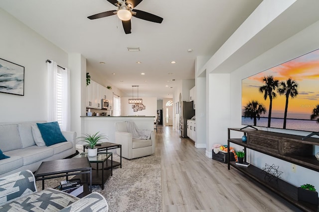 living room featuring light hardwood / wood-style flooring and ceiling fan