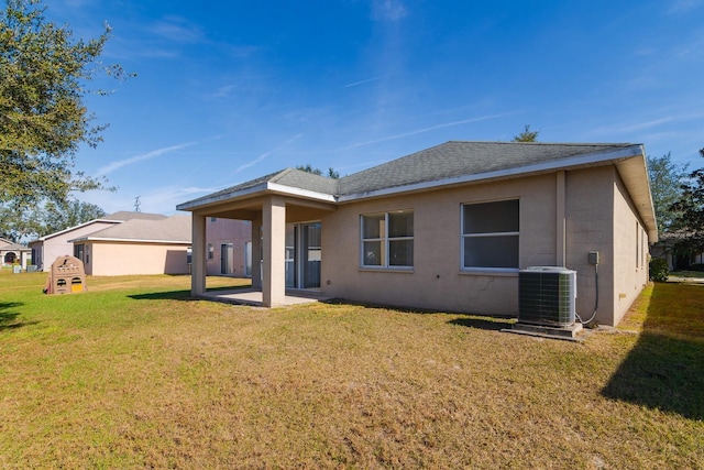 rear view of property with central AC unit, a patio area, and a lawn