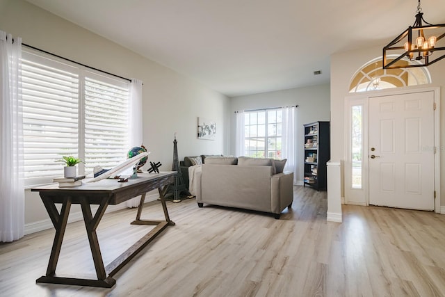 entryway with light hardwood / wood-style floors and an inviting chandelier