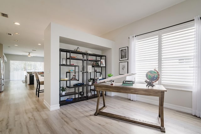 home office featuring ceiling fan and light hardwood / wood-style flooring