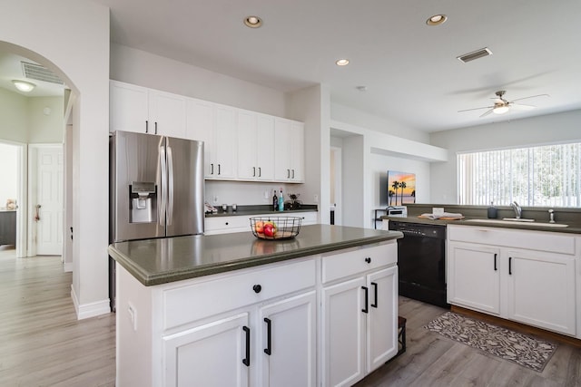 kitchen featuring dishwasher, white cabinets, sink, stainless steel fridge, and a kitchen island