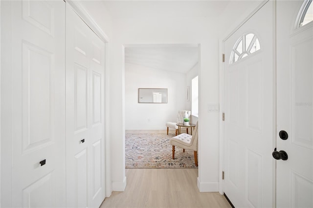 entrance foyer with light wood-type flooring and vaulted ceiling