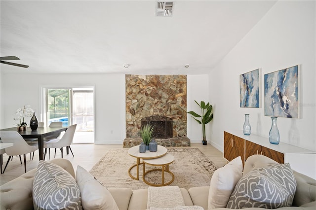 living room featuring ceiling fan, a fireplace, and light hardwood / wood-style floors