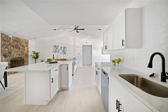 kitchen with sink, stainless steel dishwasher, light stone countertops, light hardwood / wood-style floors, and white cabinetry