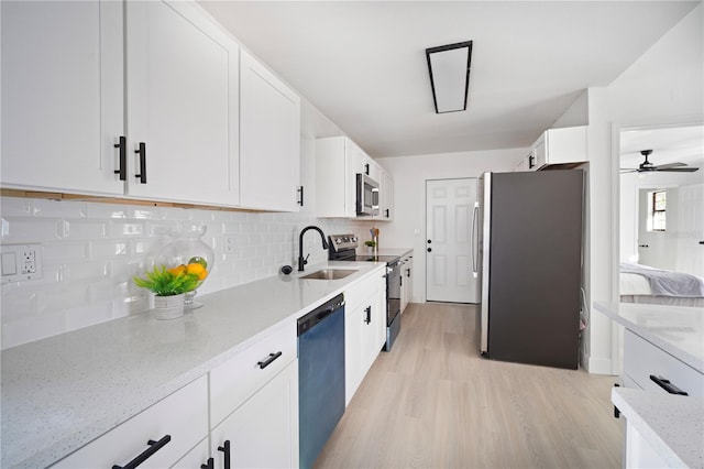 kitchen featuring light stone counters, stainless steel appliances, sink, light hardwood / wood-style flooring, and white cabinetry