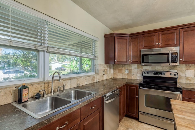 kitchen featuring decorative backsplash, sink, stainless steel appliances, and wooden counters