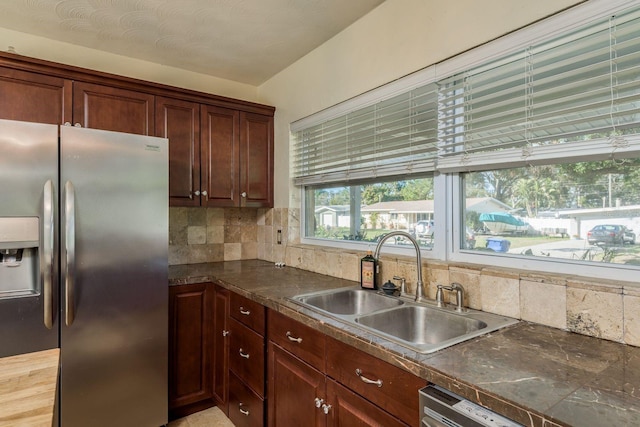 kitchen with tasteful backsplash, sink, a textured ceiling, and appliances with stainless steel finishes