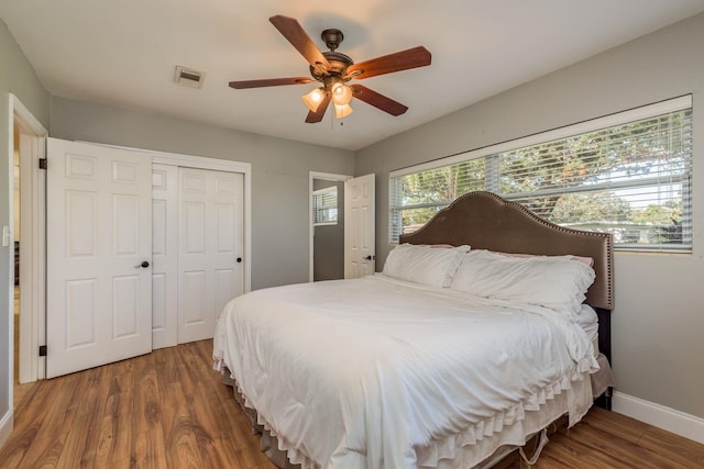 bedroom featuring dark hardwood / wood-style flooring, a closet, and ceiling fan