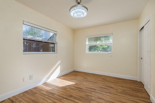 unfurnished bedroom with wood-type flooring and a closet