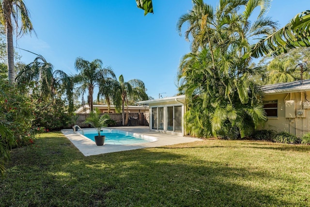 view of swimming pool with a patio, a lawn, and a sunroom