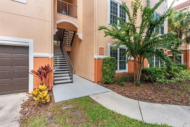 property entrance with a balcony and a garage