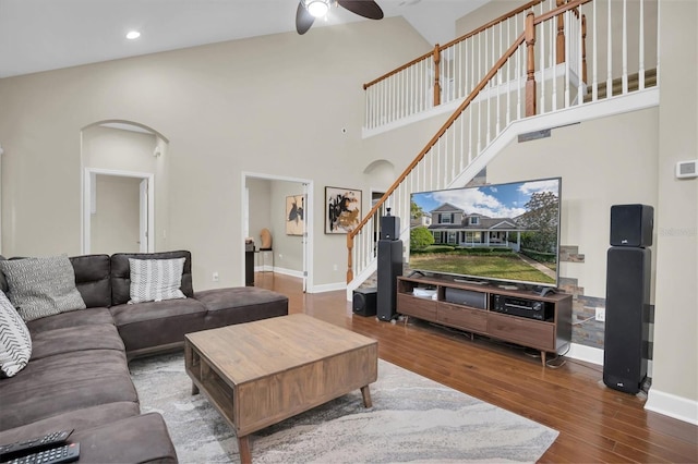 living room with ceiling fan, hardwood / wood-style floors, and high vaulted ceiling