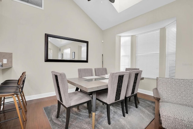 dining area featuring high vaulted ceiling, ceiling fan, and dark wood-type flooring