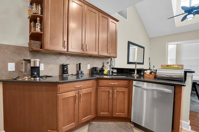 kitchen with kitchen peninsula, tasteful backsplash, stainless steel dishwasher, sink, and lofted ceiling