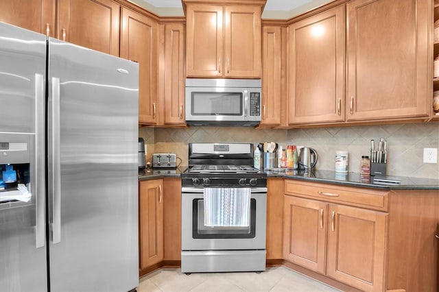 kitchen featuring decorative backsplash, light tile patterned floors, stainless steel appliances, and dark stone countertops