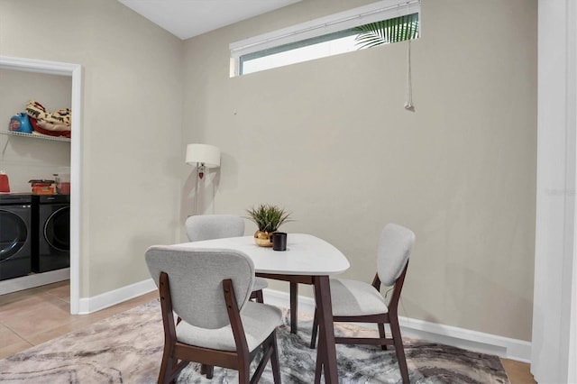 tiled dining area with washing machine and clothes dryer