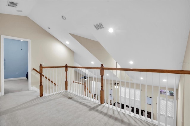 hall featuring lofted ceiling and light carpet