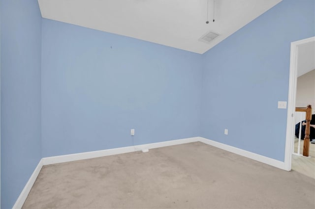 carpeted spare room featuring vaulted ceiling