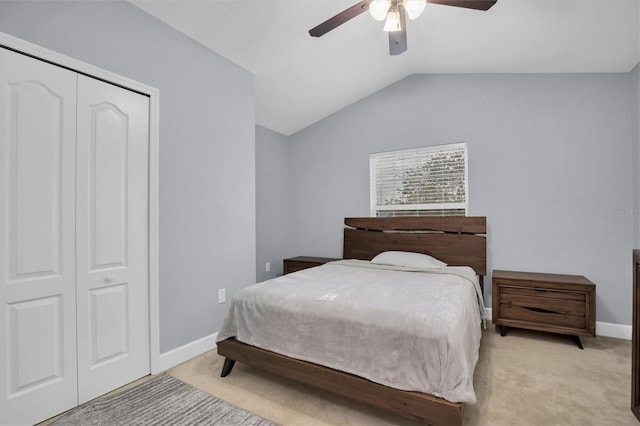 bedroom featuring ceiling fan, lofted ceiling, light carpet, and a closet