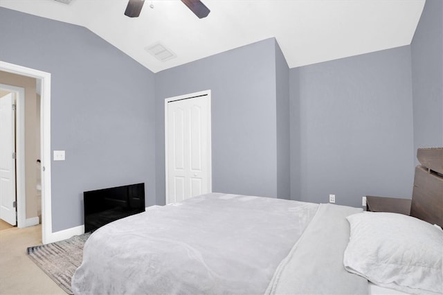 bedroom featuring a closet, light colored carpet, ceiling fan, and lofted ceiling