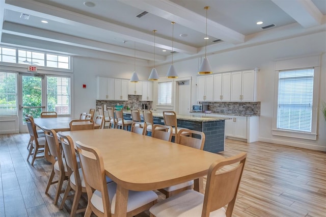 dining area with beamed ceiling and light wood-type flooring