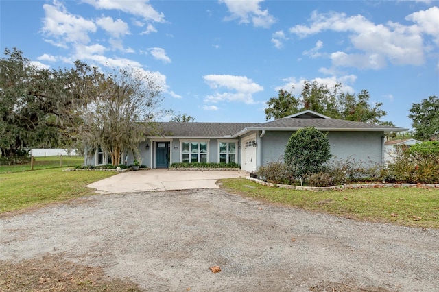 ranch-style house featuring a garage and a front lawn