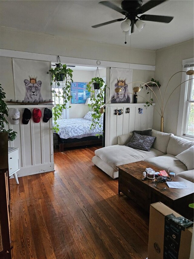 living room with ceiling fan and dark wood-type flooring