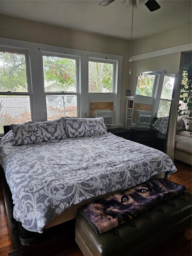 bedroom with ceiling fan, cooling unit, and dark hardwood / wood-style flooring