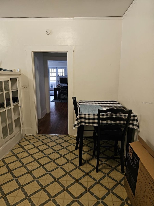 dining area with hardwood / wood-style flooring and crown molding