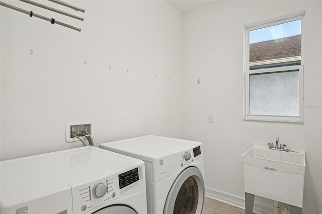 clothes washing area featuring tile patterned flooring, separate washer and dryer, and sink