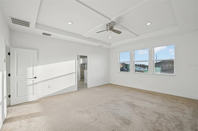 unfurnished bedroom featuring light carpet, a raised ceiling, ceiling fan, and coffered ceiling