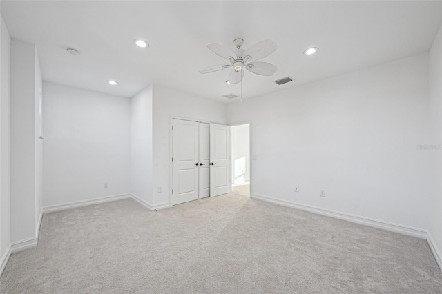 empty room with ceiling fan and light carpet