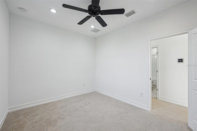 spare room with light carpet and ceiling fan