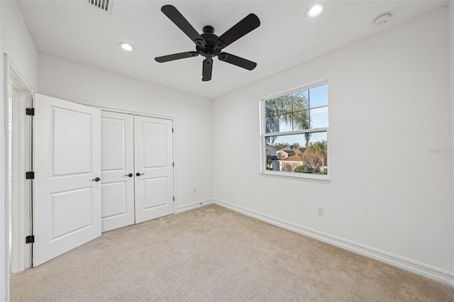 unfurnished bedroom featuring a closet, ceiling fan, and light colored carpet