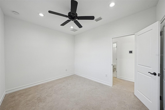 spare room with ceiling fan and light colored carpet