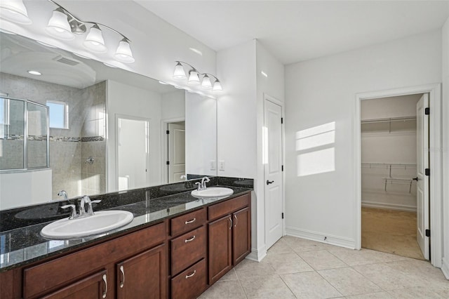 bathroom featuring tile patterned flooring, vanity, and a shower with door