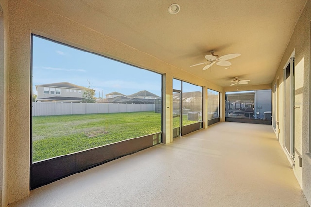 unfurnished sunroom with plenty of natural light and ceiling fan