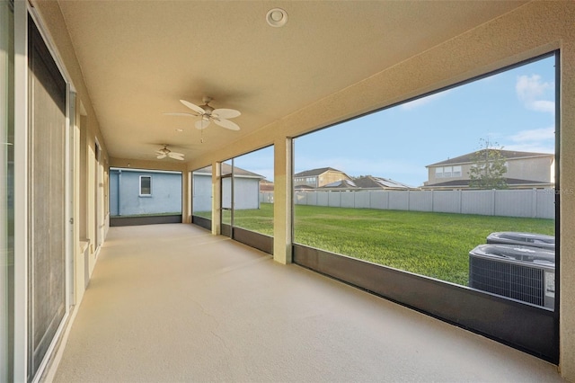 unfurnished sunroom featuring ceiling fan and plenty of natural light