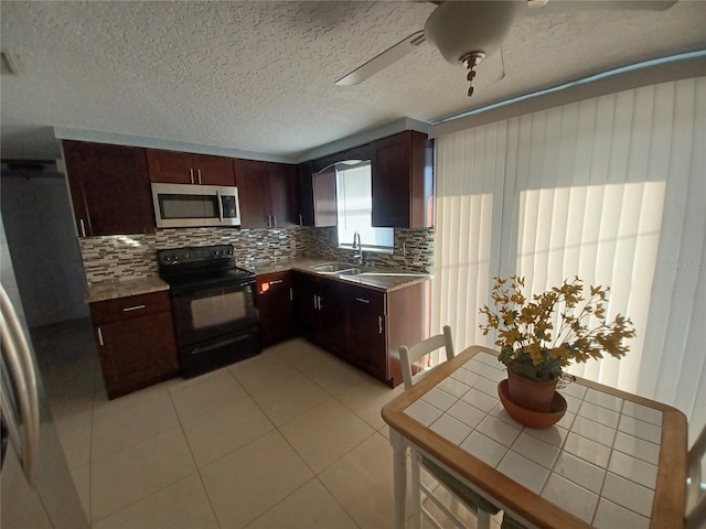 kitchen featuring black range with electric stovetop, sink, decorative backsplash, ceiling fan, and a textured ceiling