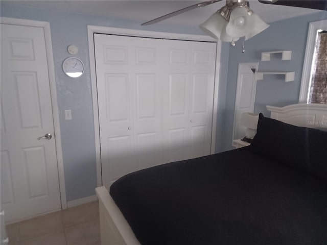 bedroom featuring ceiling fan, light tile patterned flooring, and a closet