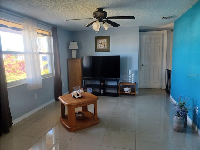 living room with light tile patterned floors, a textured ceiling, and ceiling fan