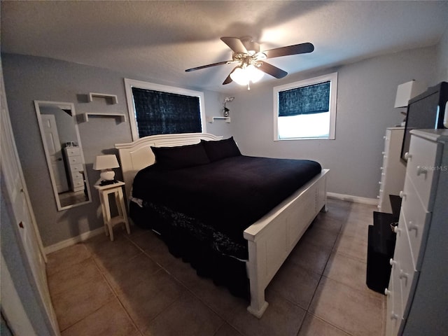 tiled bedroom with a textured ceiling and ceiling fan