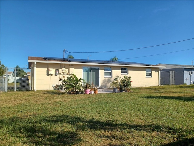 back of house featuring solar panels and a yard