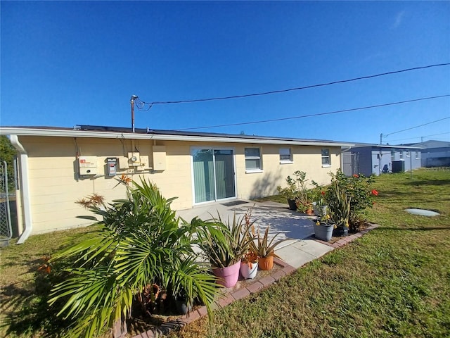 rear view of house featuring a yard and a patio