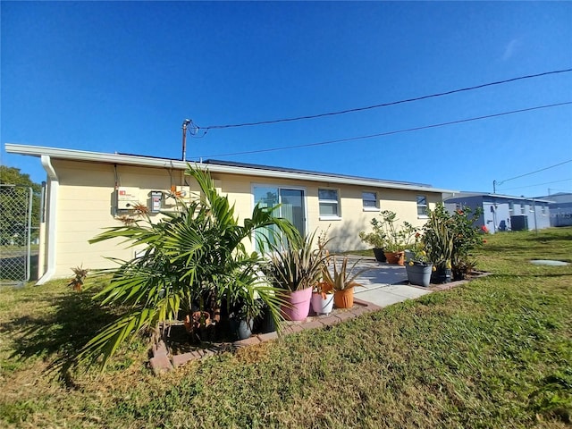 back of property with a yard and a patio