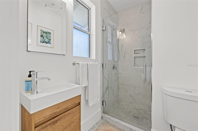 bathroom featuring vanity, an enclosed shower, and toilet