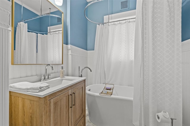 bathroom featuring shower / bath combo with shower curtain, ornamental molding, and vanity