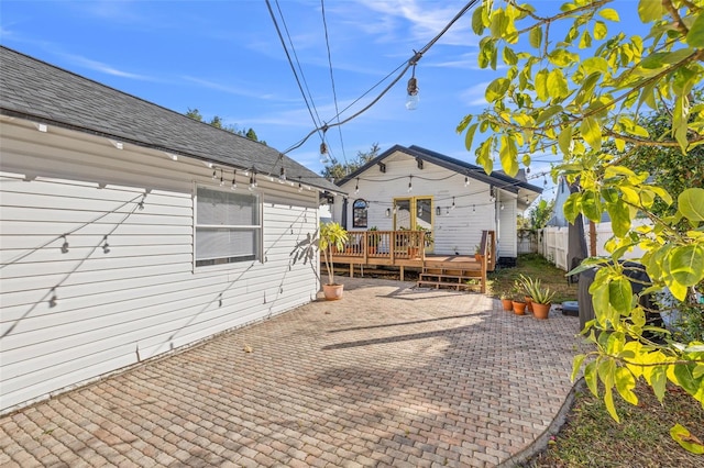 rear view of property featuring a deck and a patio