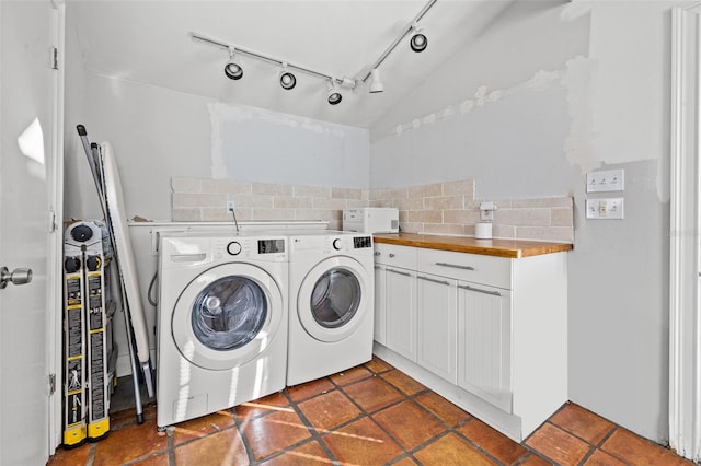 laundry room featuring dark tile patterned flooring, cabinets, and separate washer and dryer