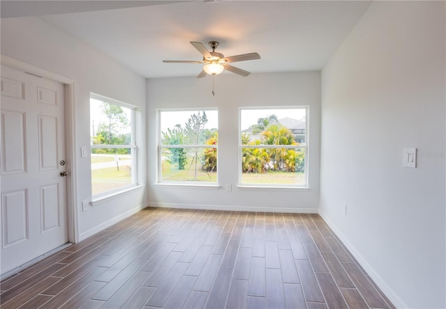 unfurnished sunroom with ceiling fan